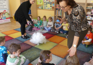 Dzieci siedzą na dywanie przyglądają się tworzeniu się pary.