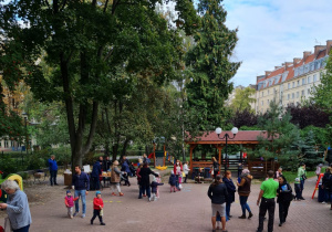 Plac zabaw, na którym rodzice wraz z dziećmi biorą udział w pikniku.