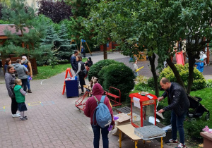 Stoisko z popcornem oraz grupa rodziców z dziećmi oraz pracownicy przedszkola.